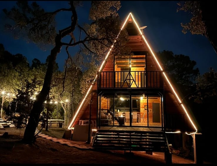 Cabaña El Amanecer iluminada por la noche